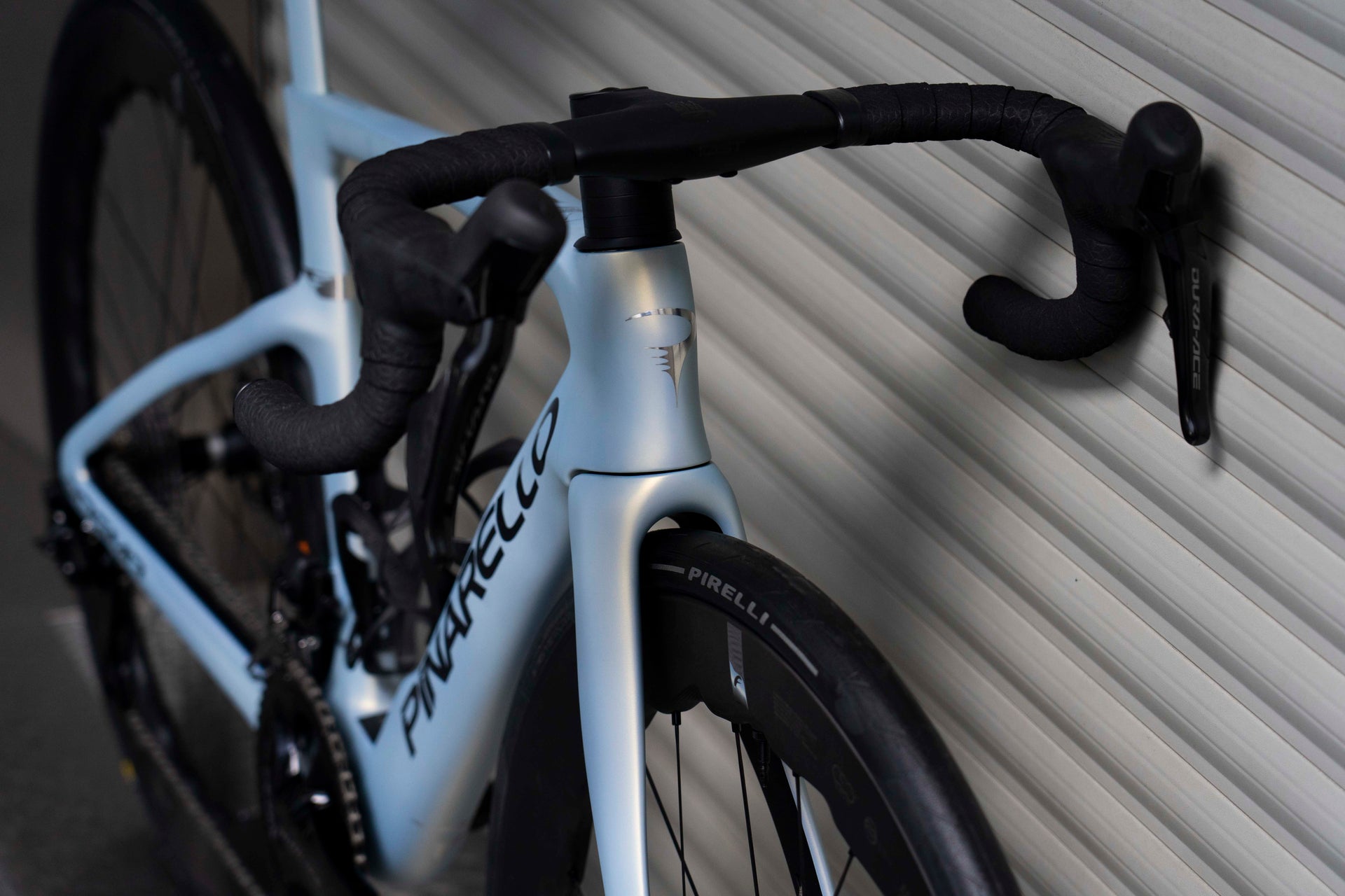 Front-end view of the integrated MOST carbon handlebar and Shimano Dura-Ace Di2 levers on the Pinarello Dogma F complete bicycle by Cicli Corsa.