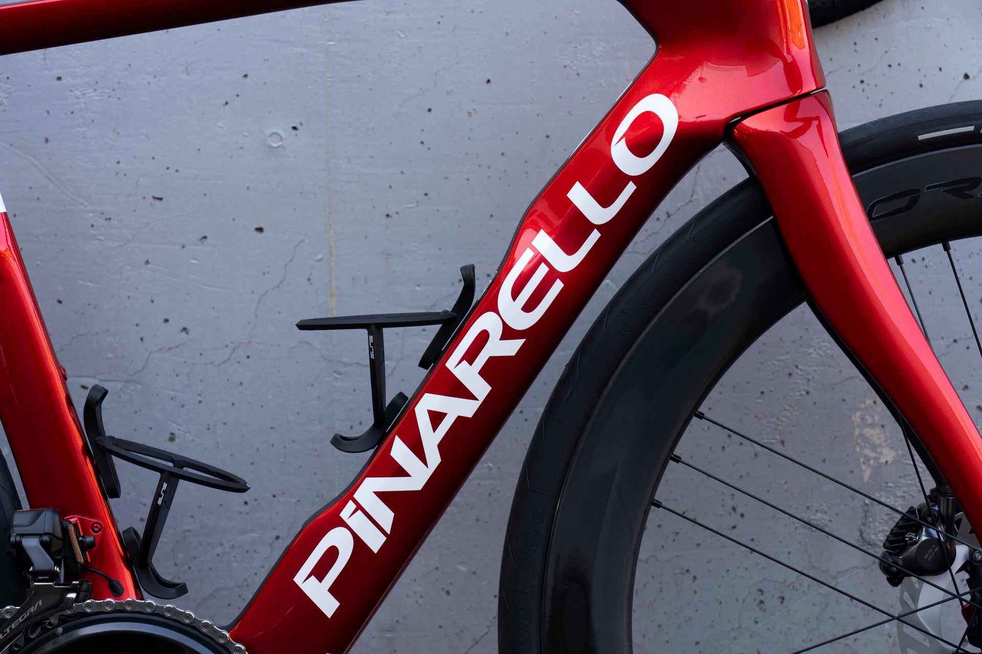 Pinarello branding on the down tube highlighting the glossy Starry Red 530 paint finish on the Dogma F complete bicycle by Cicli Corsa.