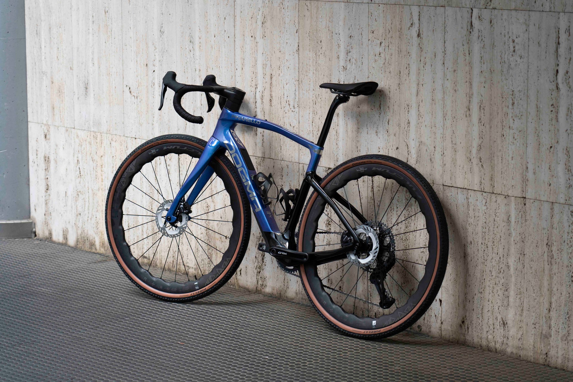 Non-drive side view of the Pinarello Dogma GR premium carbon gravel complete bicycle featuring Fulcrum Sharq wavy wheels, assembled by Cicli Corsa.