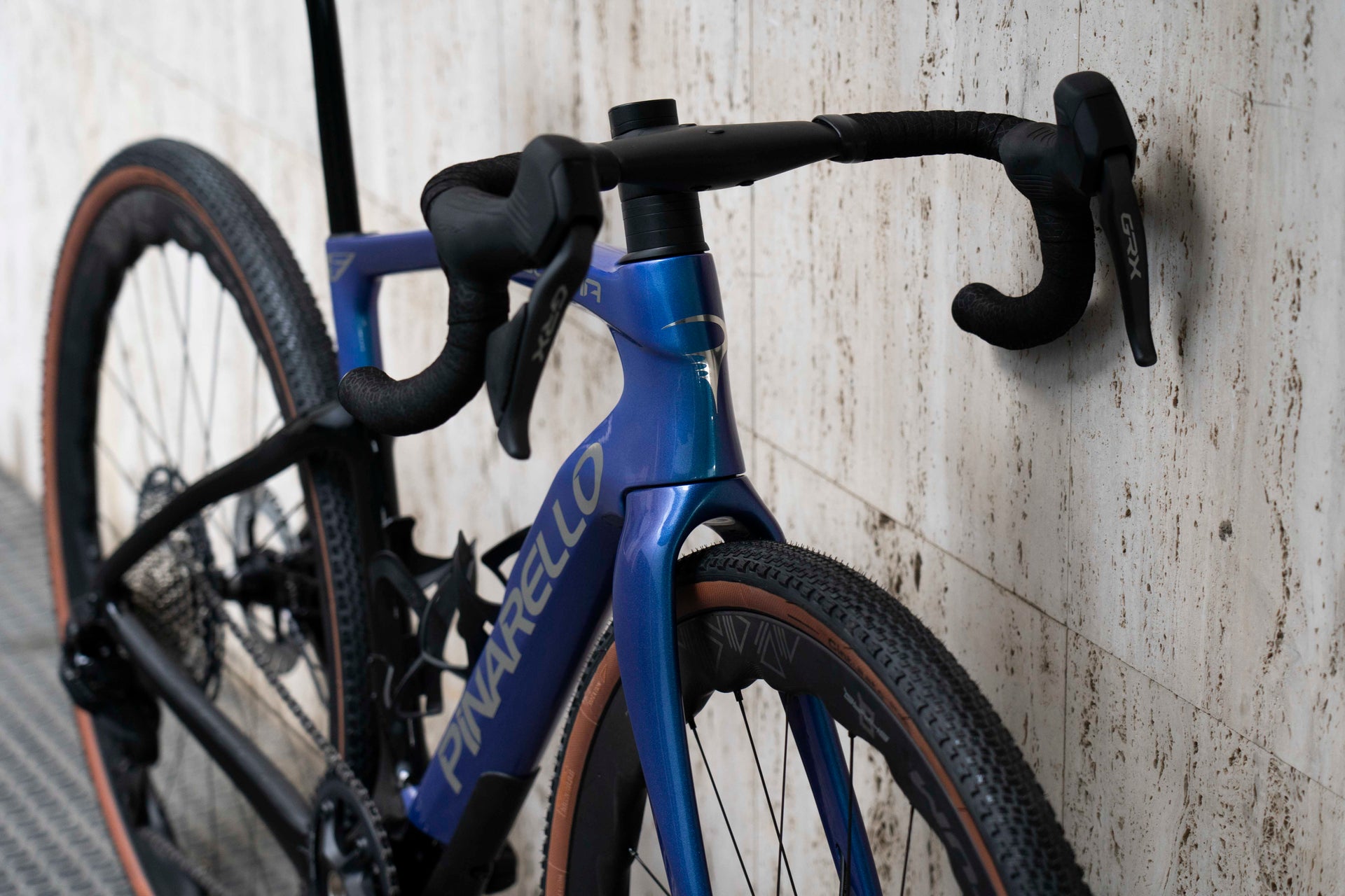 Front-end view of the integrated MOST carbon cockpit and Shimano GRX 12-speed shifter levers on the Pinarello Dogma GR Luxter Blue Shiny complete bicycle by Cicli Corsa.