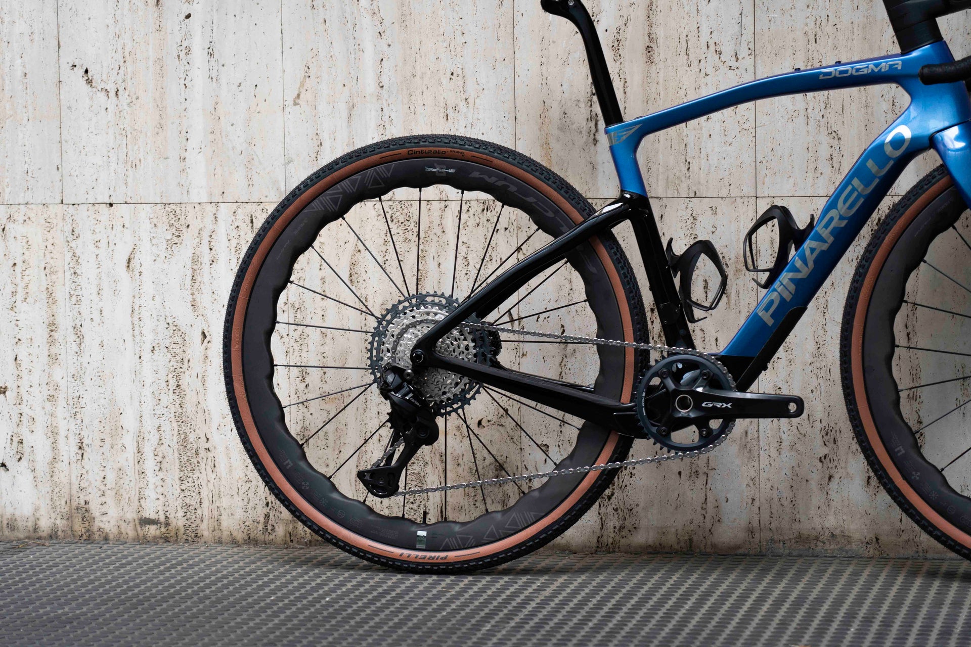 Asymmetric rear carbon triangle and wide gravel tire clearance design on the high-performance Pinarello Dogma GR complete bicycle by Cicli Corsa.