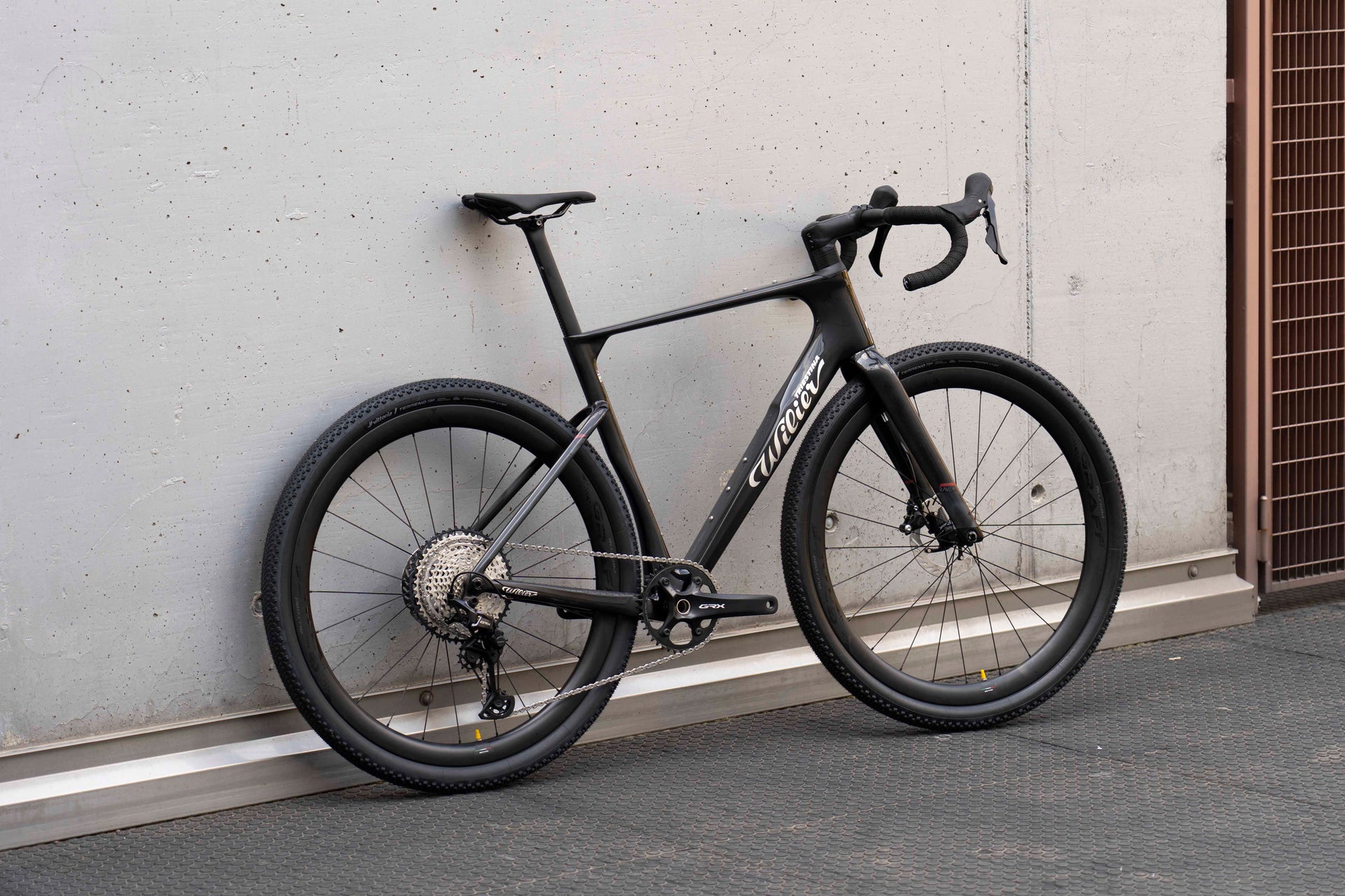 Drive side view of the Wilier Triestina Rave SLR Glitch Black gravel bicycle with Shimano GRX 1x12-speed and Miche Graff Allroad wheels, custom built by Cicli Corsa.