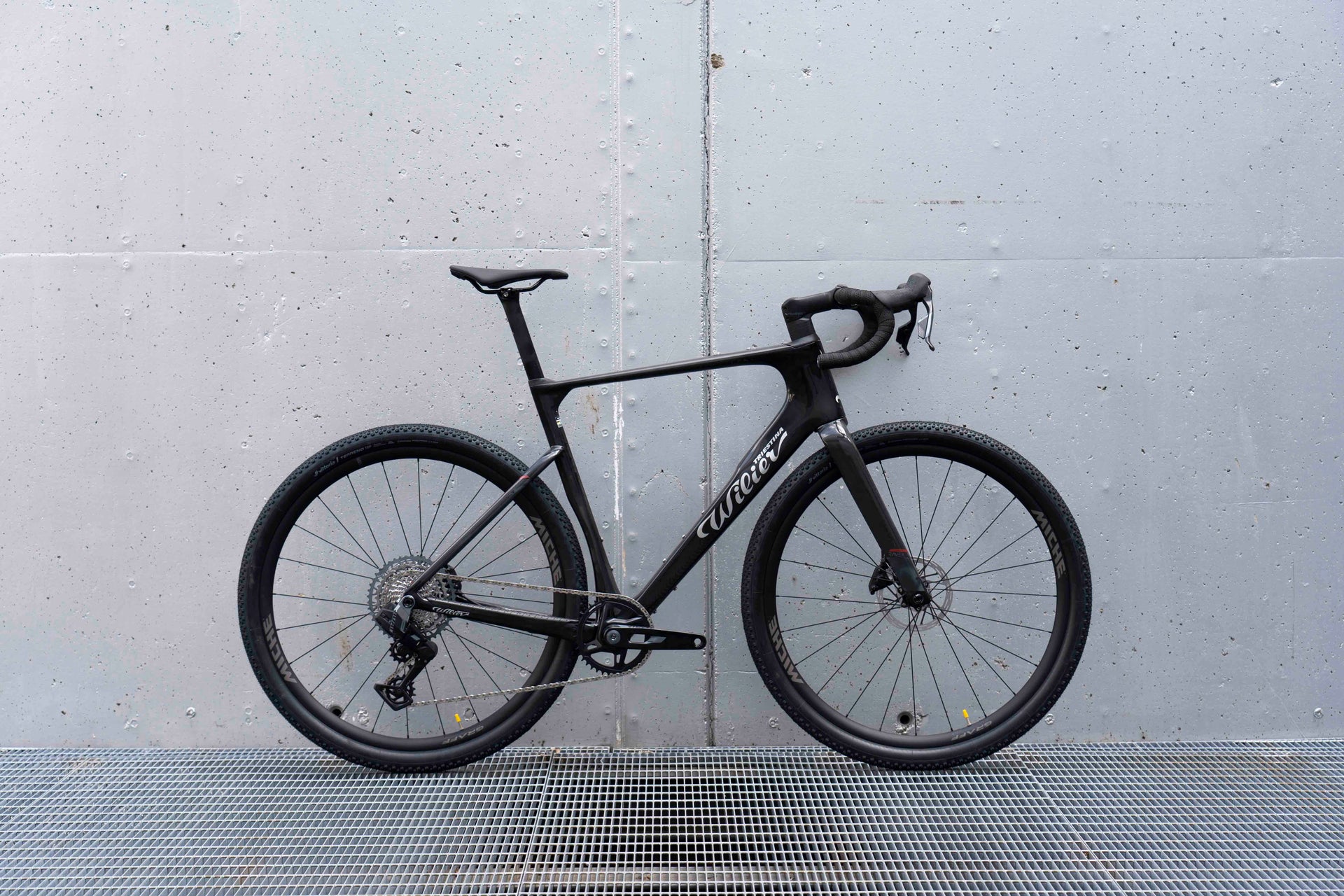 Drive side view of the Wilier Triestina Rave SLR Glitch Black complete gravel bicycle with SRAM Rival XPLR AXS and Miche Graff wheels, custom built by Cicli Corsa.