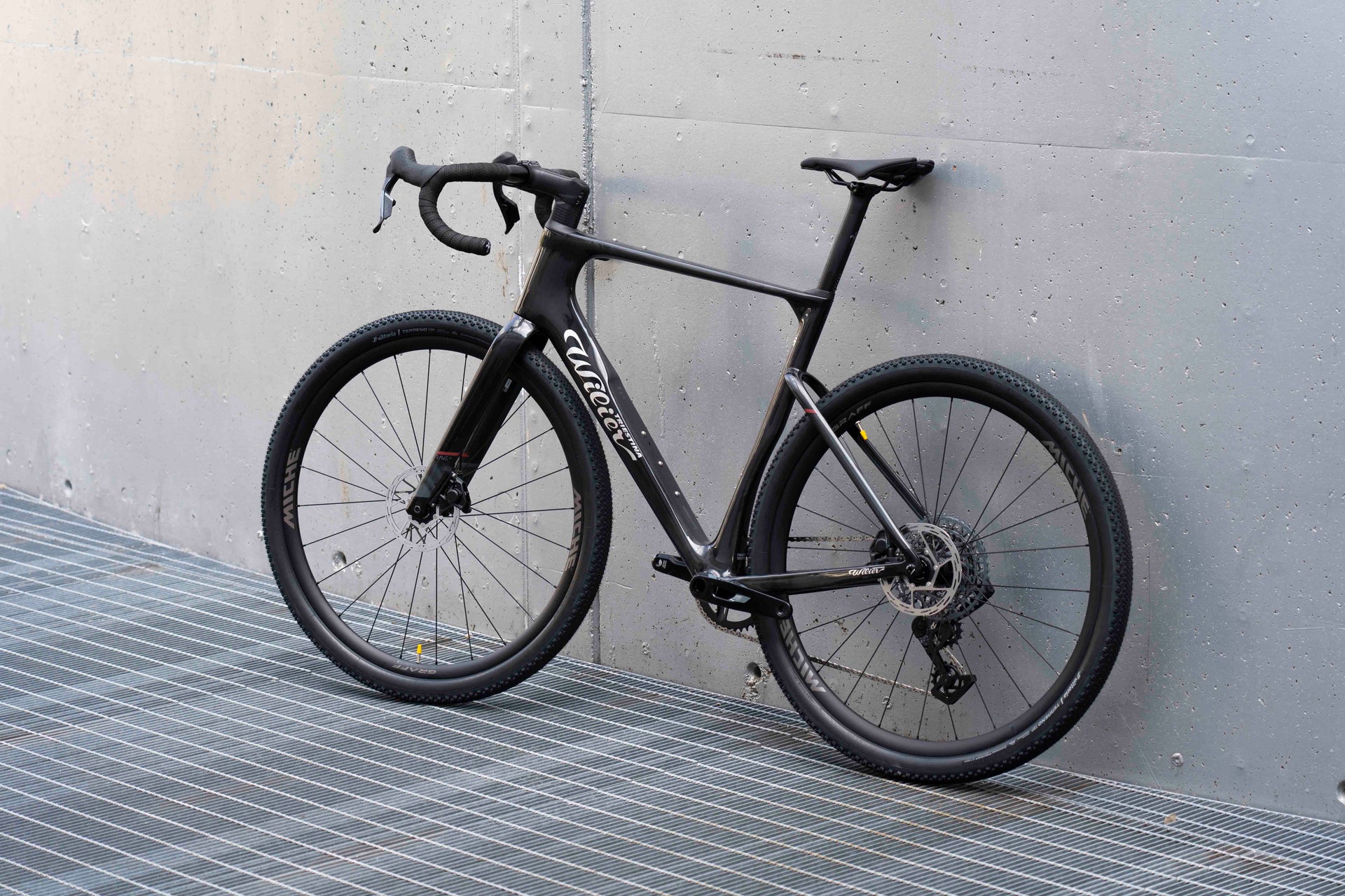 Drive side view of the Wilier Triestina Rave SLR Glitch Black complete gravel bicycle with SRAM Rival XPLR AXS and Miche Graff wheels, custom built by Cicli Corsa.